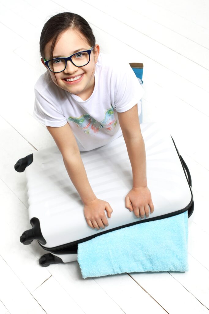 dziecko pakujące się na obóz - kolonie